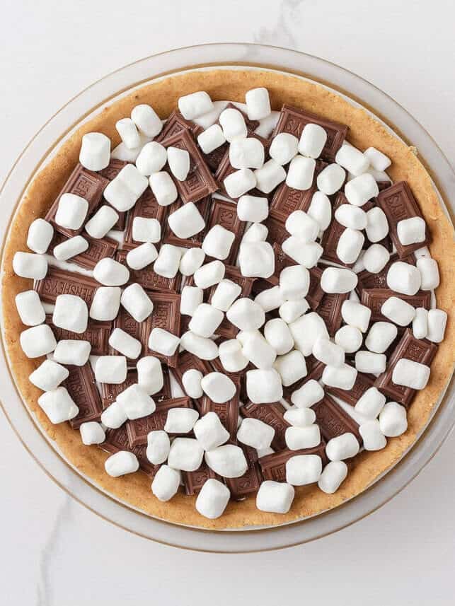 S’mores pie filling with Hershey chocolate bars and mini marshmallows layered inside a graham cracker cookie crust.