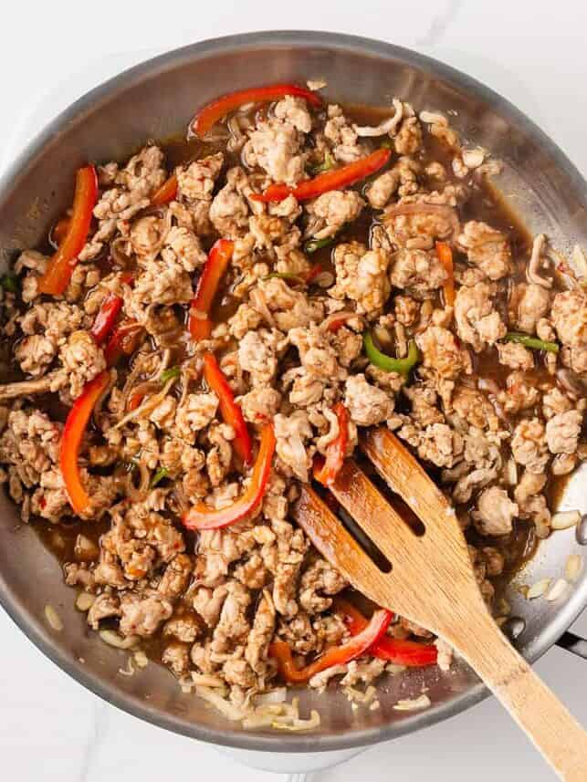 This easy Thai basil chicken recipe is bold, savory, and ready in under 30 minutes. It's everything you love about your favorite Thai food, made right at home! Thai basil chicken simmering with peppers in savory sauce.