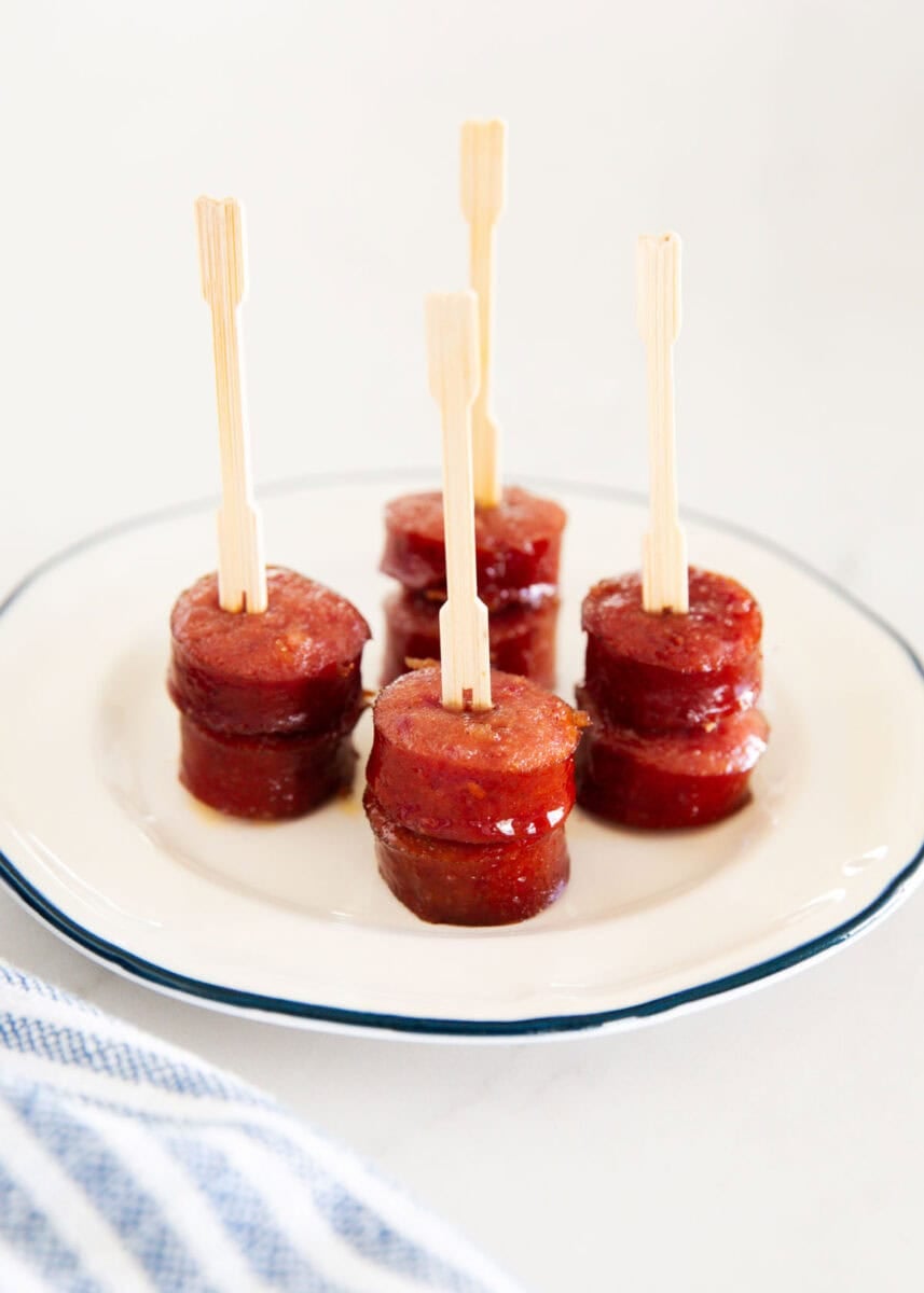Close-up of glazed brown sugar kielbasa bites with party picks.