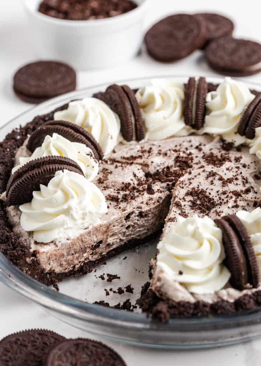 Creamy no bake Oreo cheesecake in an Oreo crust with a slice removed, showing the cookies and cream filling.