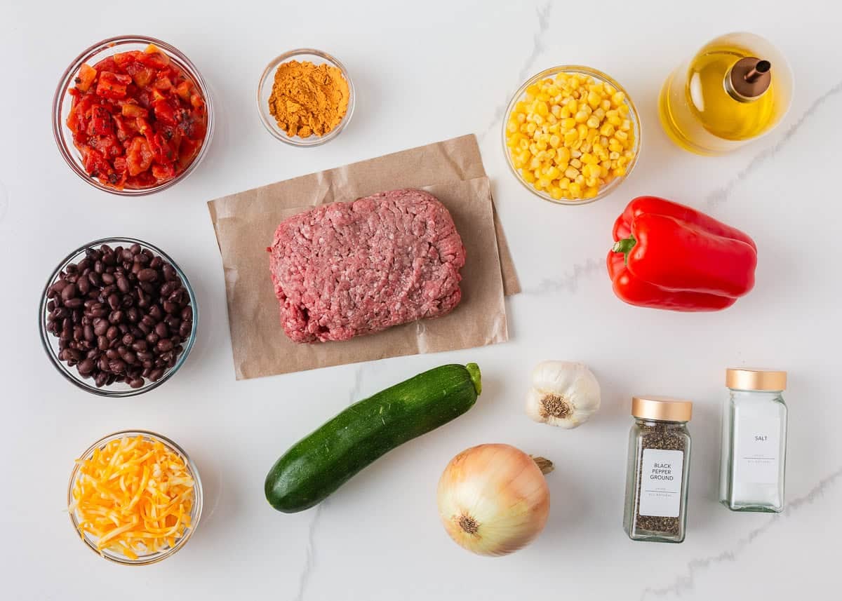 Ground beef and zucchini skillet ingredients with black beans, corn, fire roasted tomatoes, bell pepper, onion, cheese and taco seasoning.