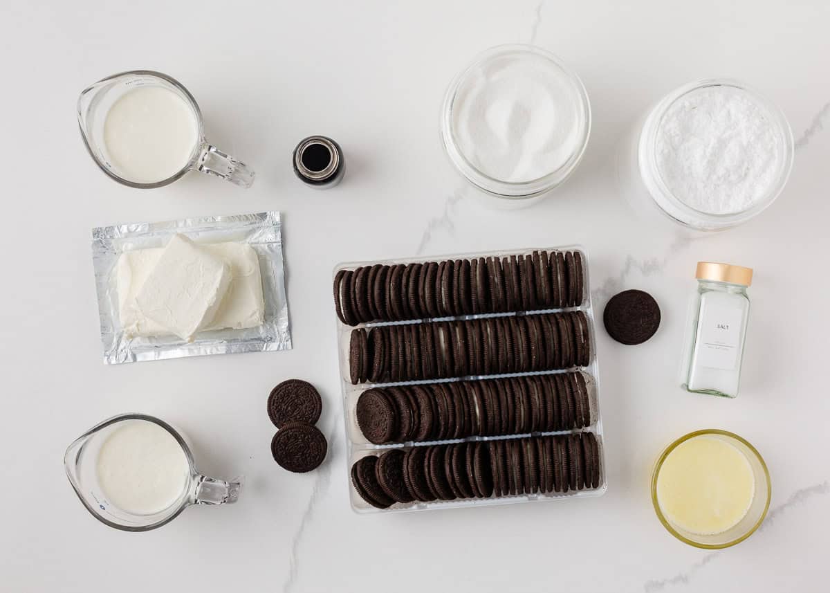 Ingredients to make no bake Oreo cheesecake including Oreos, cream cheese, heavy whipping cream, sugar, powdered sugar, vanilla, butter and salt.