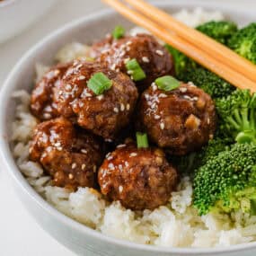 Sticky Asian pork meatballs served over rice with broccoli, green onions and sesame seeds.