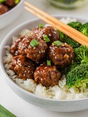 Sticky Asian pork meatballs served over rice with broccoli, green onions and sesame seeds.