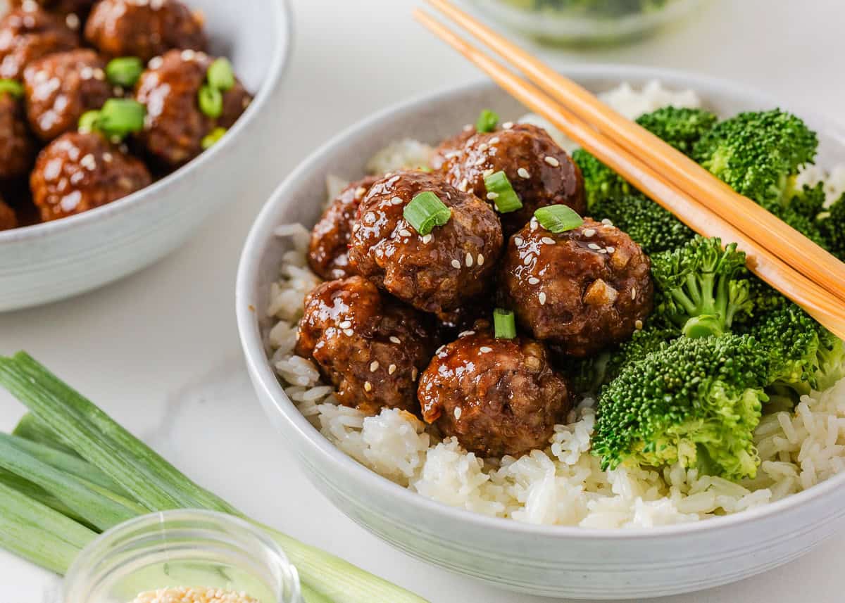 Sweet and sticky pork meatballs with rice, broccoli, sesame seeds and green onions.