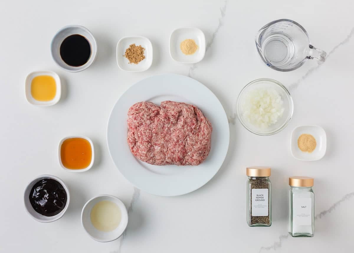 Ingredients for sweet and savory Asian pork meatballs including ground pork, onion, hoisin sauce, soy sauce, honey, rice vinegar, sesame oil and seasonings.