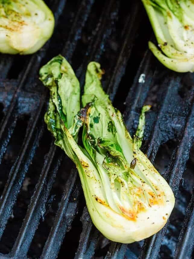 Baby bok choy grilling until lightly charred and tender.