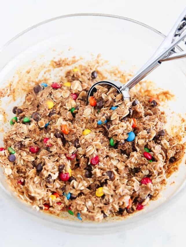 Monster energy ball dough with M&Ms and oats, ready to scoop with a cookie scoop.
