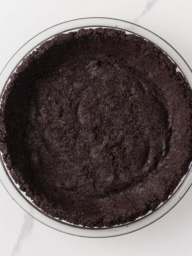 Oreo crust pressed into the bottom and up the sides of a glass pie plate.