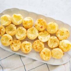 Easy Brazilian cheese bites (Pão de queijo) arranged on a platter for serving.