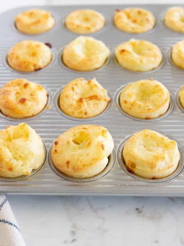 Freshly baked Brazilian cheese bites in a mini muffin tin.