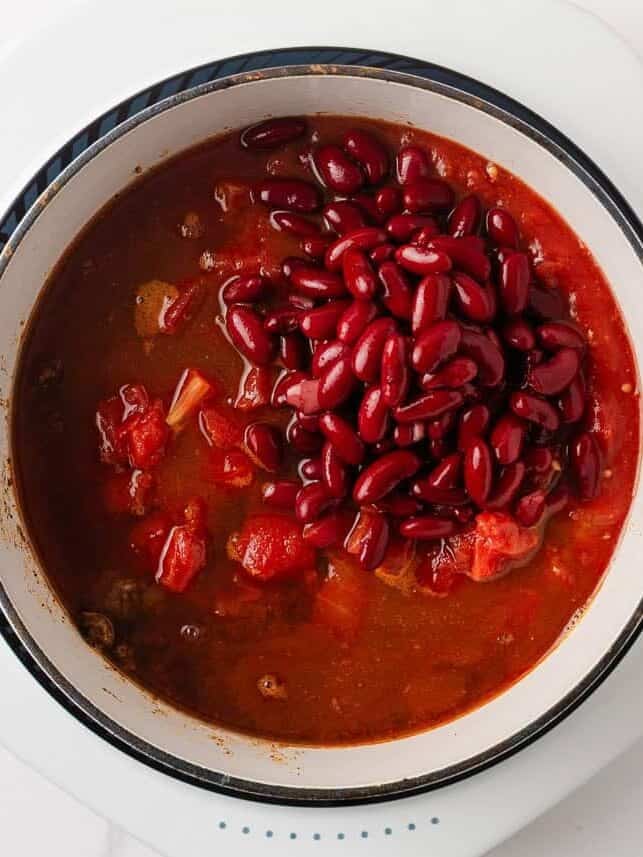 Kidney beans added to the tomato and ground beef mixture while making chili mac.