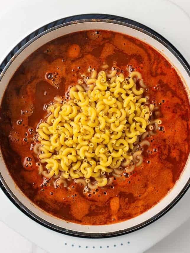 Dry elbow macaroni added to the simmering tomato, beef and bean mixture for one-pot chili mac.
