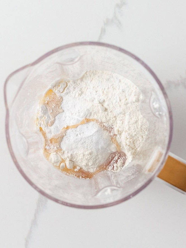 Cottage cheese, eggs, flour, baking powder, salt and maple syrup added to a blender for cottage cheese pancake batter.