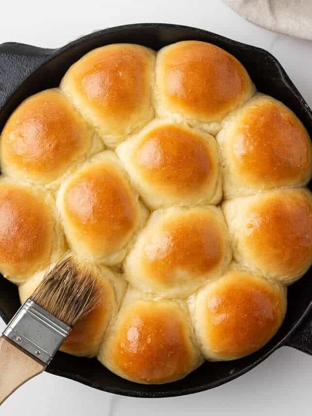 Golden skillet dinner rolls brushed with melted butter after baking.