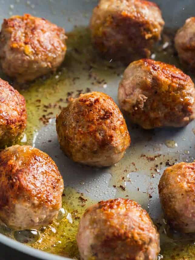 Cooked chicken meatballs in the skillet.