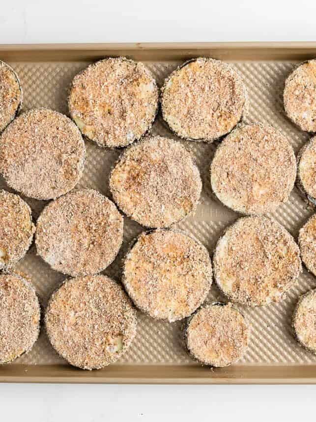 Breaded eggplant on baking sheet.