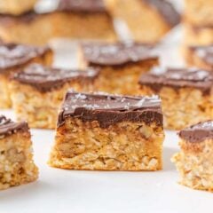 Chocolate-topped 5 star bars arranged on a white surface with one bar centered in front.