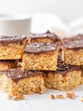 Stacked 5 star bars with a graham cracker, coconut and pecan base topped with chocolate.