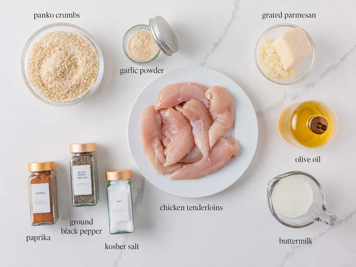 Ingredients for baked chicken tenders including chicken tenderloins, panko breadcrumbs, buttermilk, Parmesan, olive oil and seasonings.