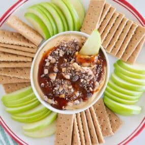 Overhead view of caramel apple cheesecake dip with sliced Granny Smith apples and graham crackers for dipping.