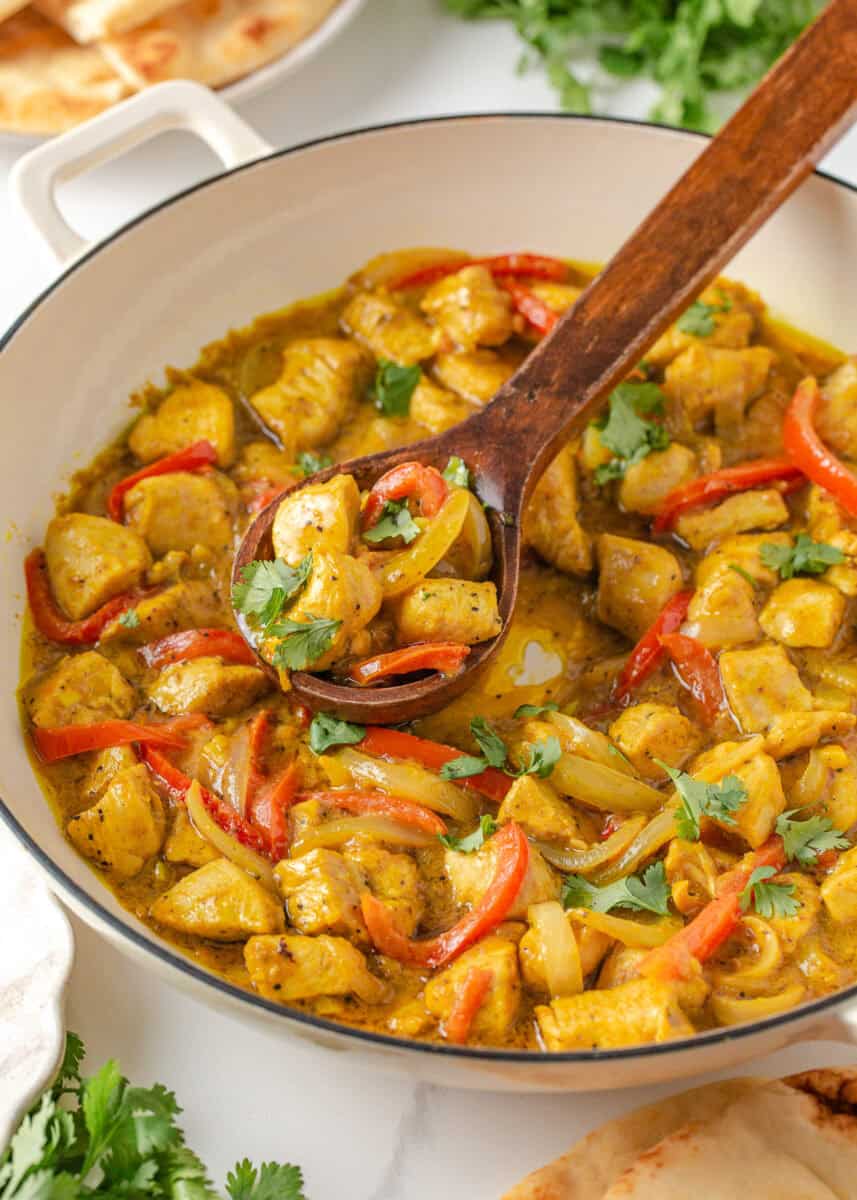 Coconut curry chicken with red bell peppers and onions in a creamy curry sauce with cilantro.