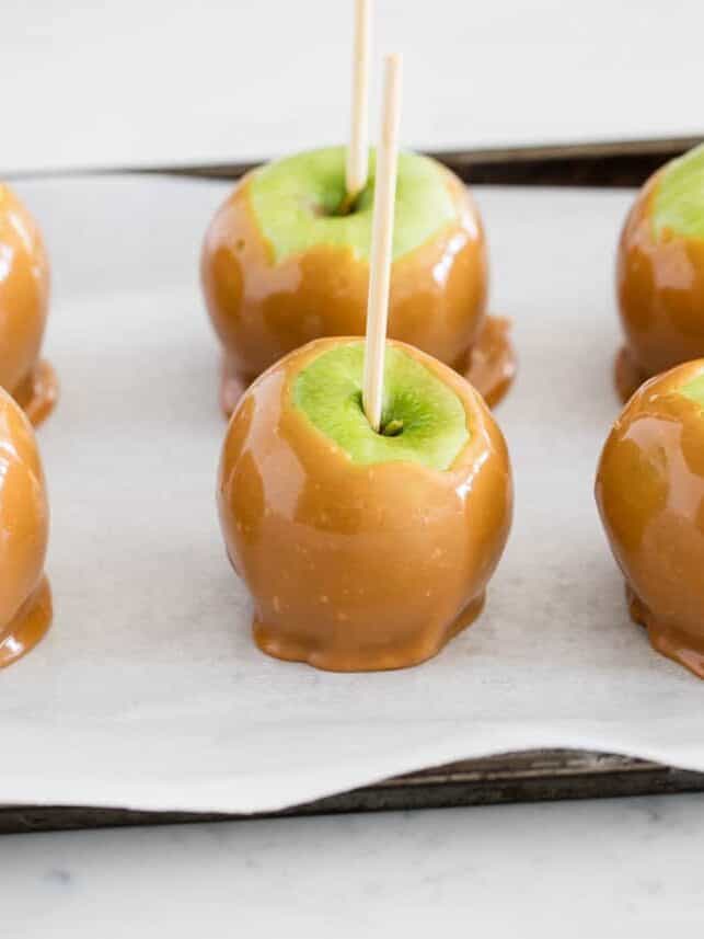 Caramel apples on baking sheet.