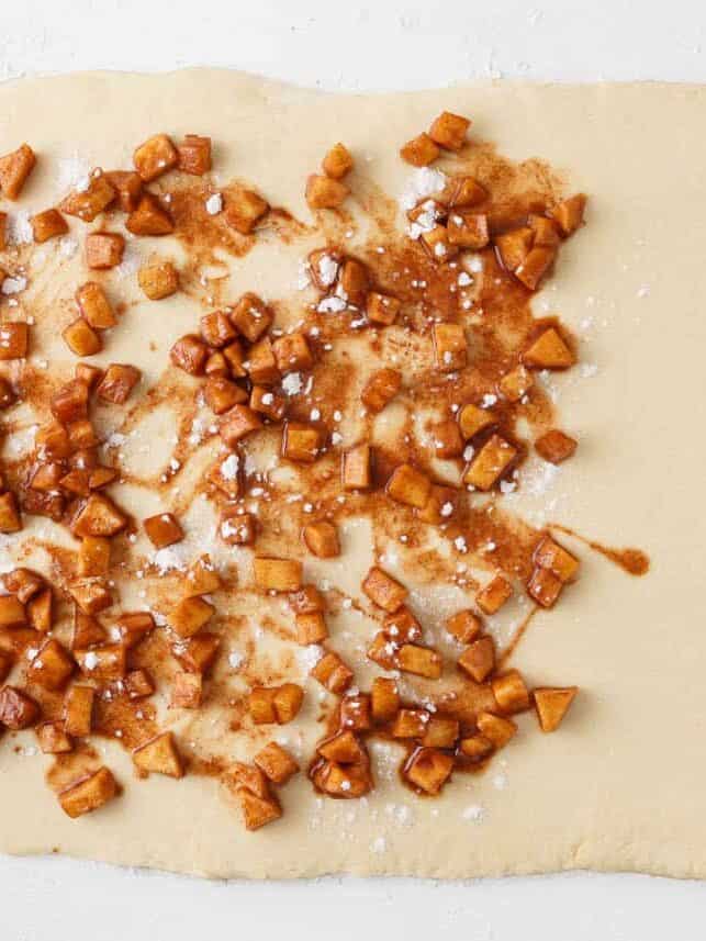 Cinnamon apple filling spread over rolled-out yeast dough.