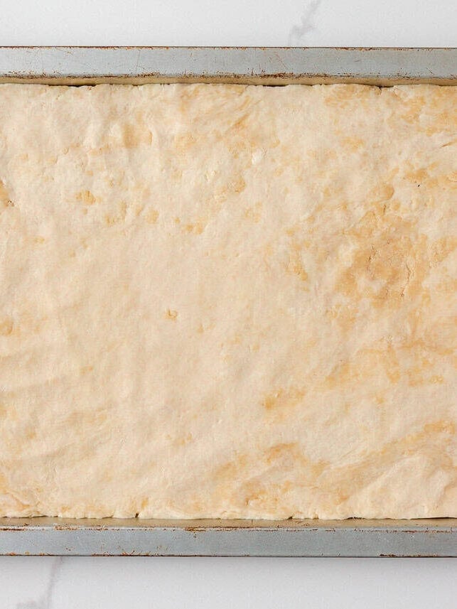 Pastry dough pressed into a sheet pan for slab apple pie.