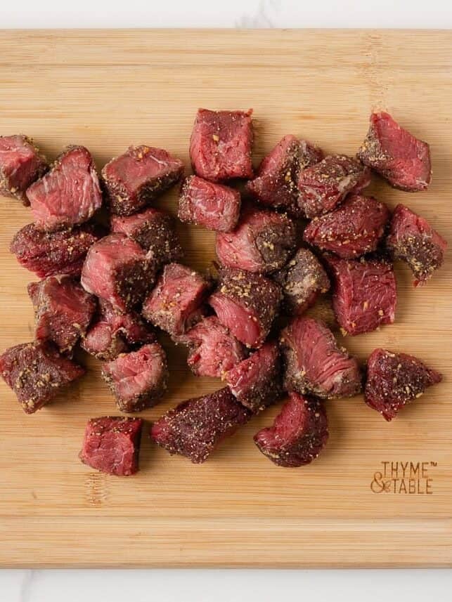 Garlic butter steak and potatoes in a cast iron skillet with browned potatoes, tender steak bites and fresh thyme.
