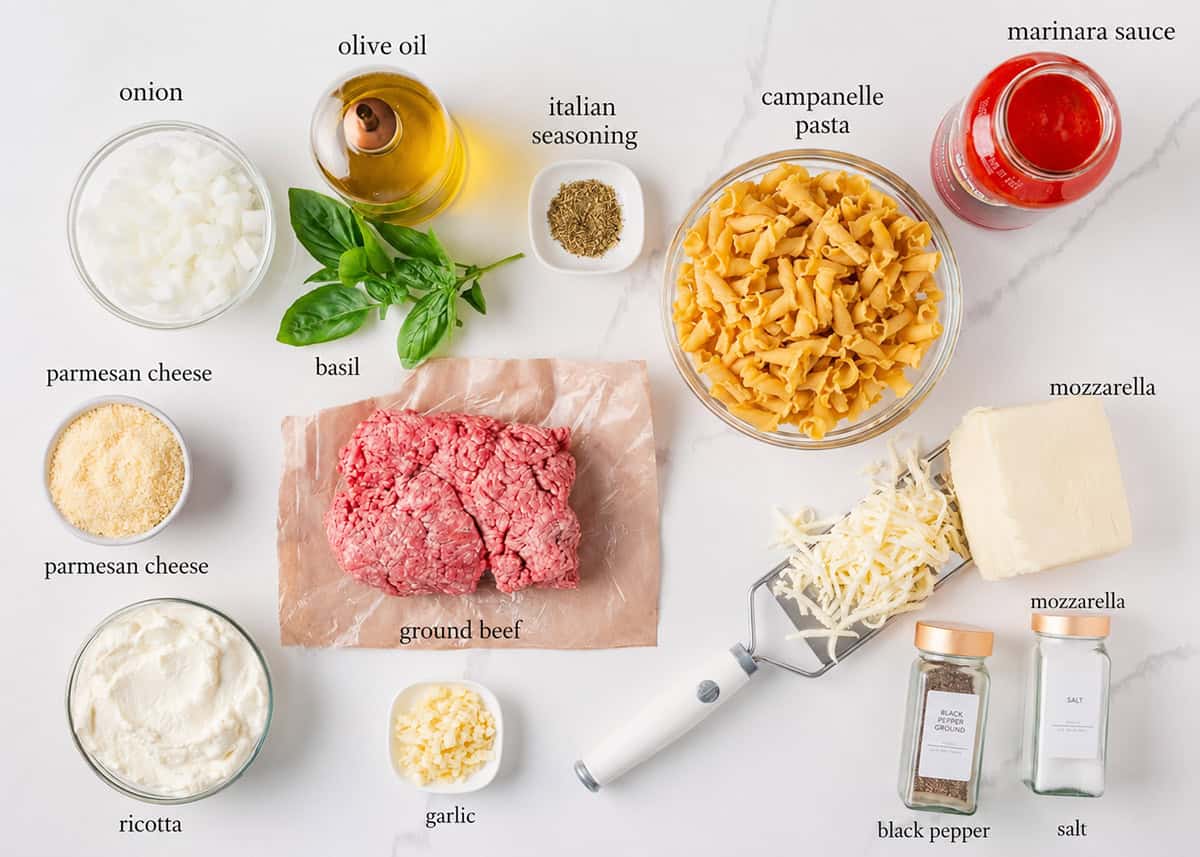 This lasagna casserole has all the classic flavors of traditional lasagna but in an easy-to-make casserole. This family-friendly baked pasta dish is perfect for weeknight dinners! Ingredients for lasagna casserole including campanelle pasta, ground beef, marinara, ricotta, mozzarella, Parmesan, onion, garlic, basil and seasonings.