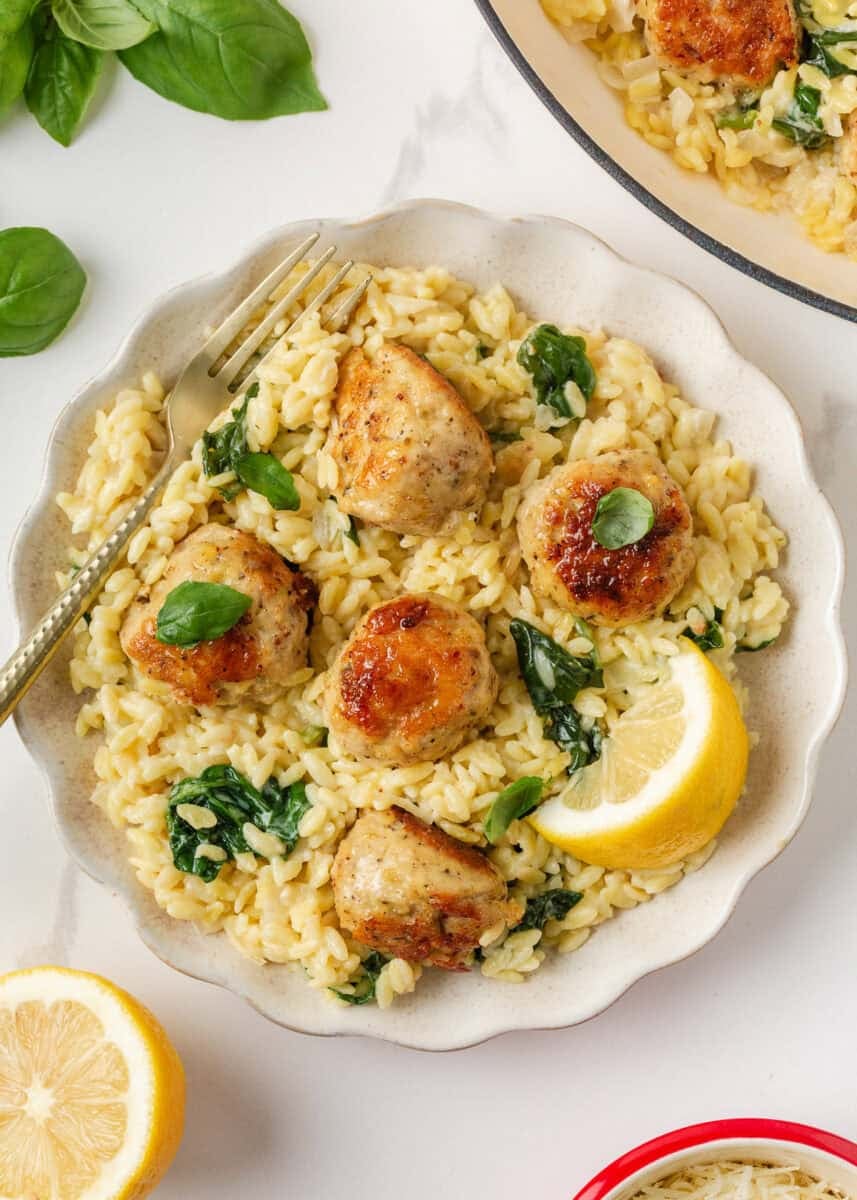 Creamy chicken meatballs with orzo and spinach served with fresh basil and lemon.