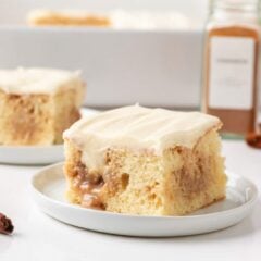 Cinnamon roll poke cake slices with cream cheese frosting and cinnamon filling.