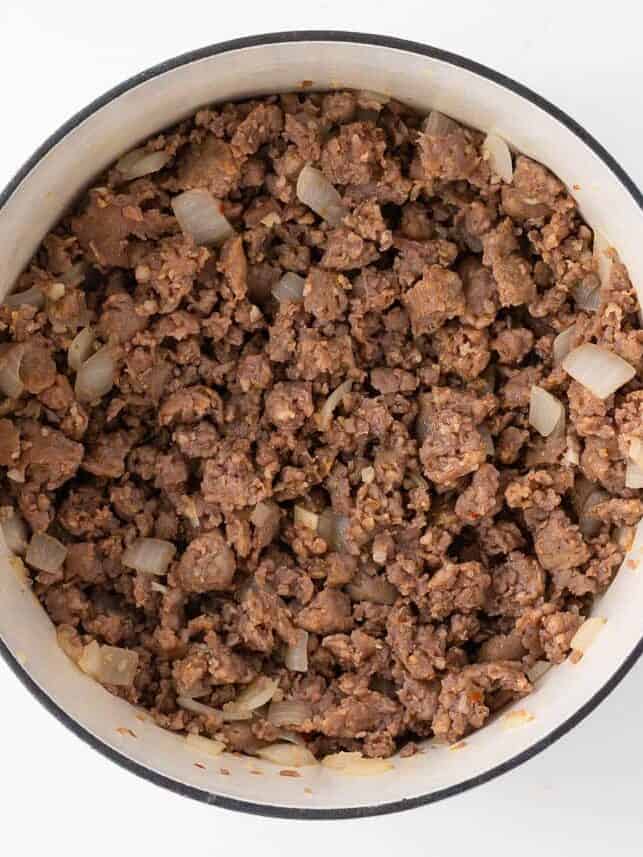 Browning Italian sausage in skillet for slow cooker lasagna soup.