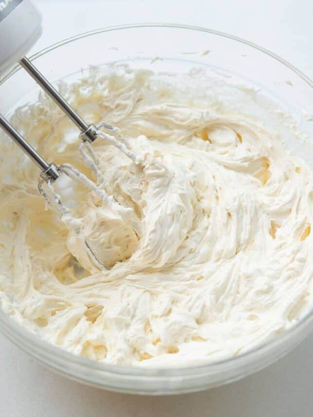 Mixing cream in a glass bowl.