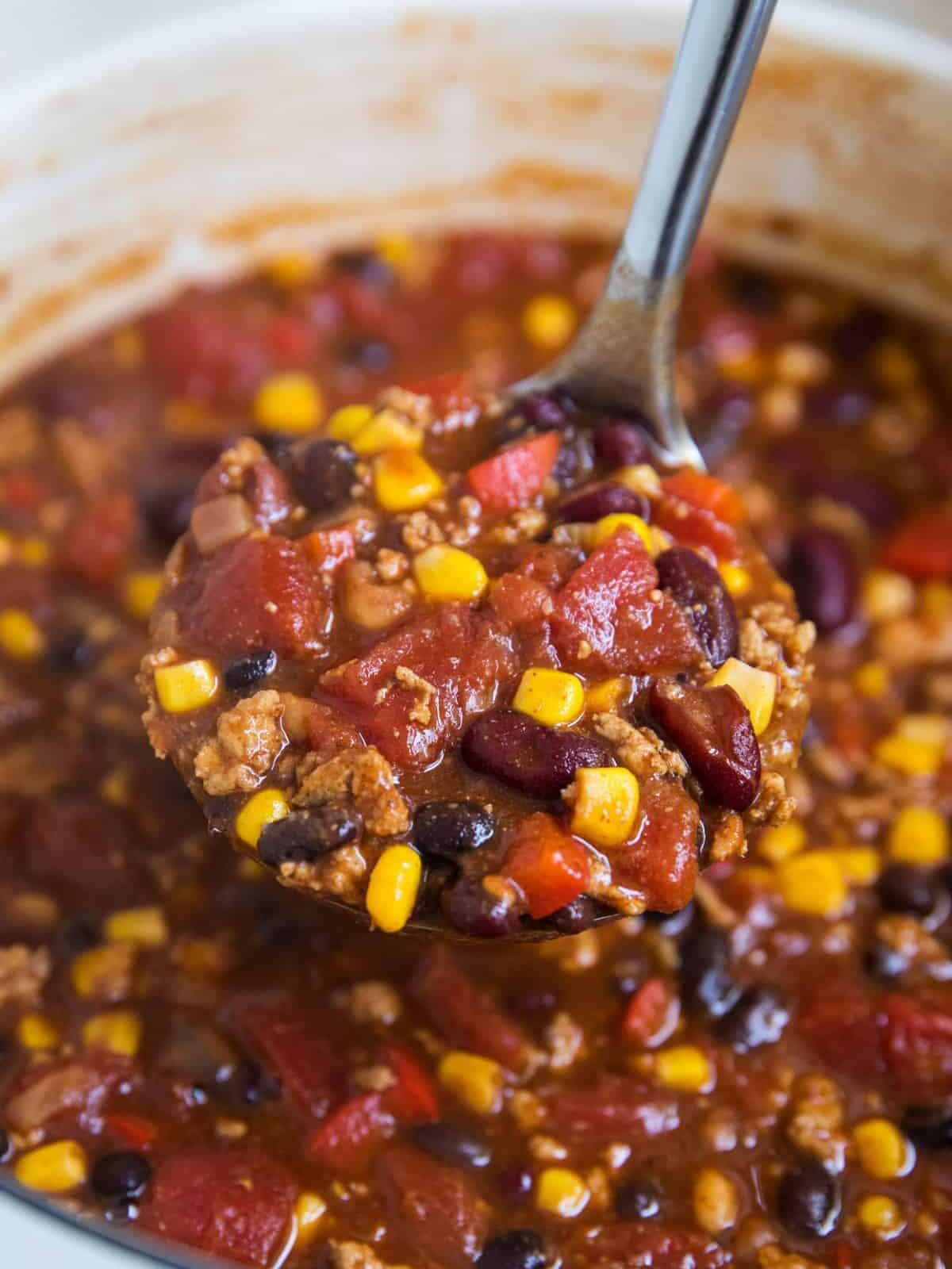 Healthy turkey chili simmering with ground turkey, beans, tomatoes and corn.
