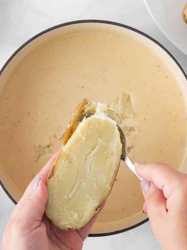 Scooping potatoes back into potato soup.