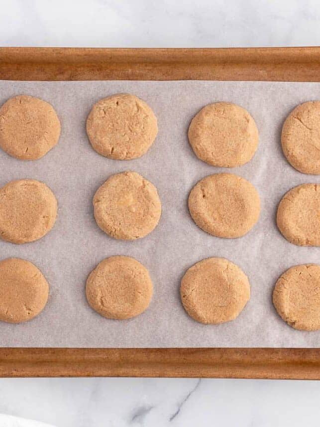 Baked peanut butter cookies ready to be decorated like spiders.