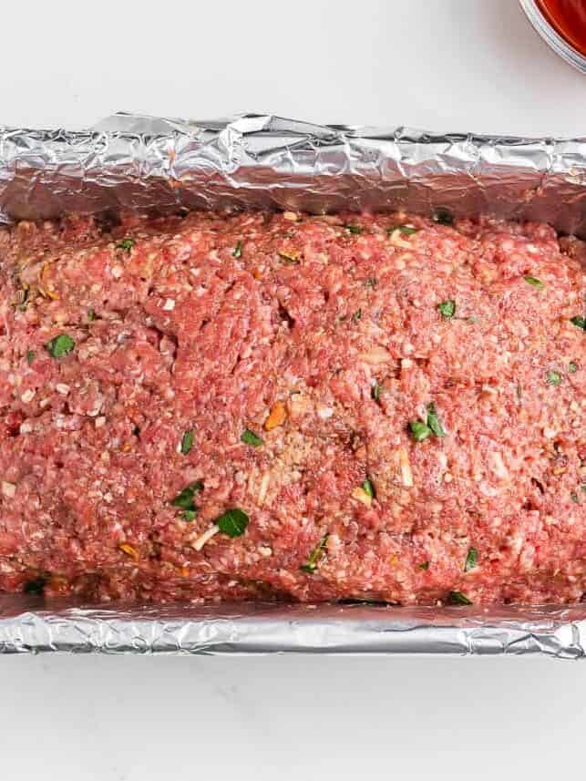 Unbaked lipton onion soup meatloaf in a foiled lined pan.