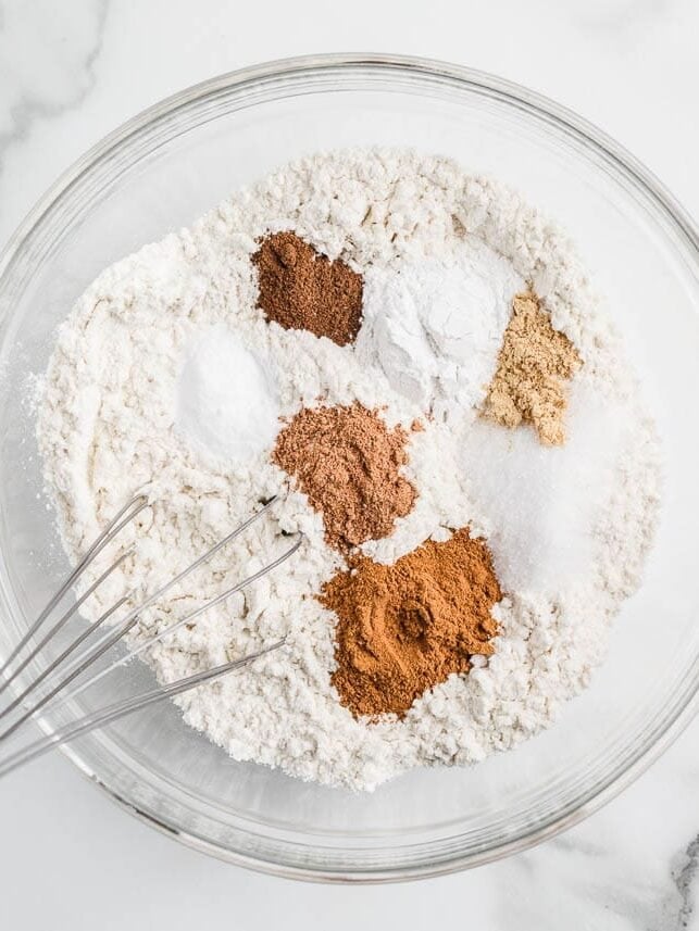Whisking flour in a bowl with warm spices.