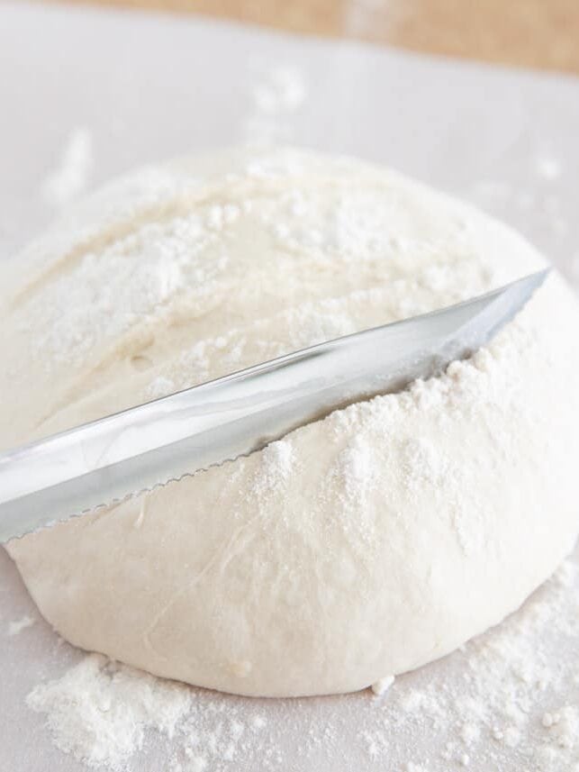 Scoring 3 ingredient artisan bread dough with a knife.