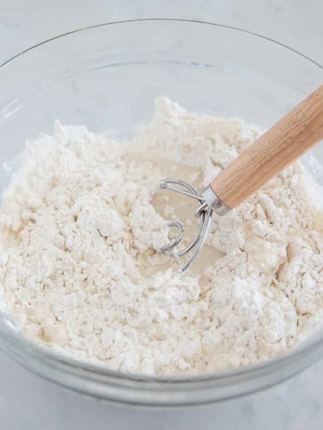 Mixing flour, water and yeast in a bowl for 3 ingredient artisan bread.