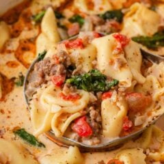 Close-up of creamy Tuscan tortellini soup with cheese tortellini, Italian sausage, spinach and tomatoes.