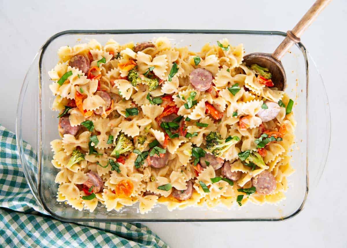 Baking dish of Boursin cheese pasta with farfalle, sausage, broccoli and fresh basil.