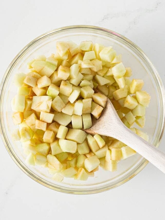 Peeled and diced apples in a glass bowl for homemade apple turnover filling.