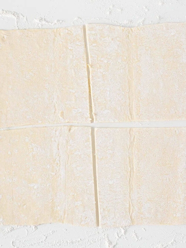 Puff pastry sheet cut into four squares for making apple turnovers.