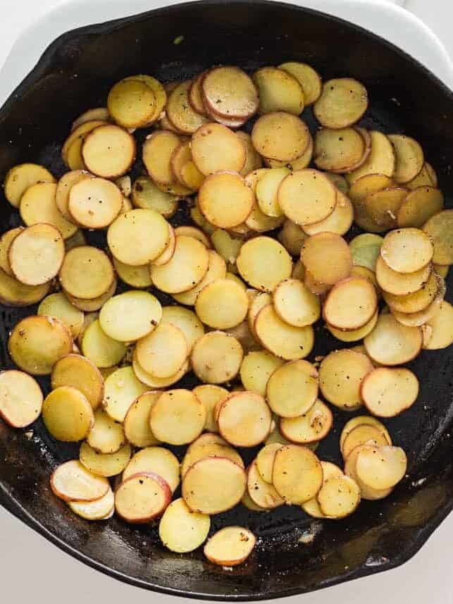 Sliced potatoes ready to cook in a skillet.