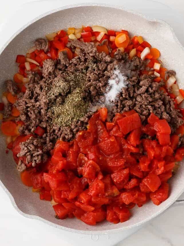 Ground beef, diced tomatoes and seasonings added to the sautéed vegetables.
