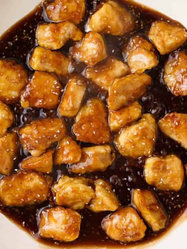 Chicken simmering in honey sesame sauce.