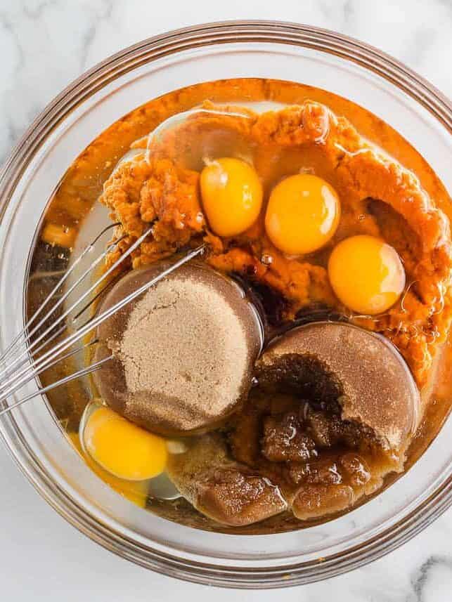 Pumpkin puree, eggs, brown sugar, oil and vanilla in a mixing bowl before whisking.